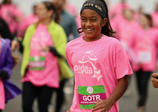 A GOTR girl smiling near the 5K finish line.